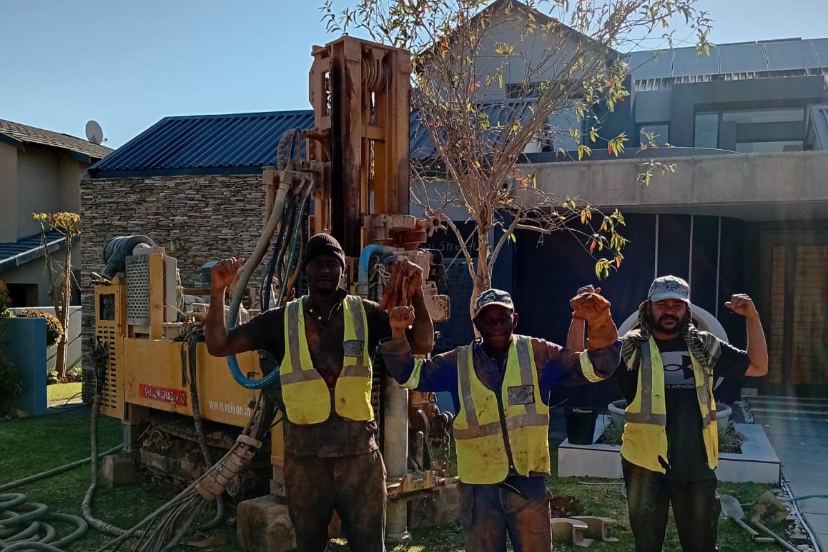 EVZ Projects drilling team standing in front of borehole drilling rig on site